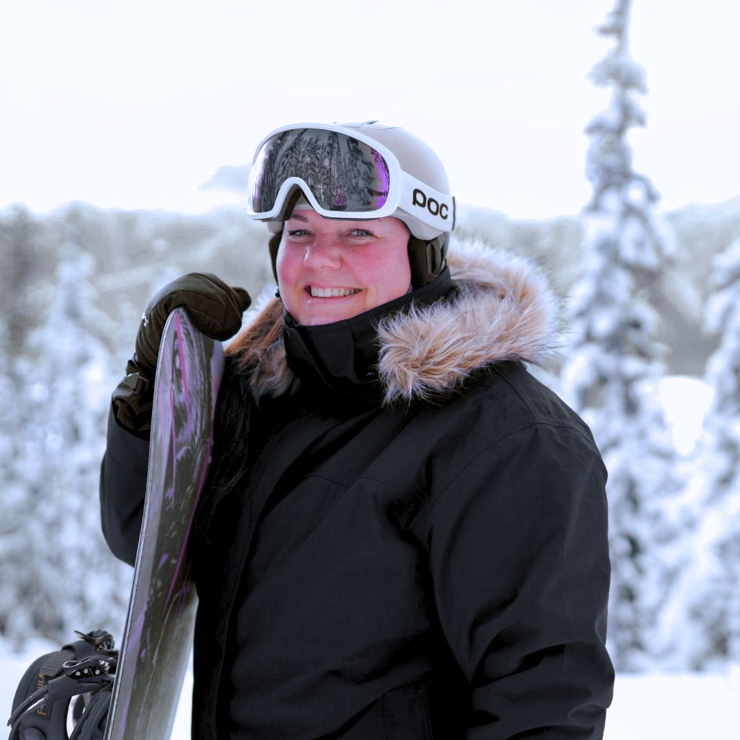 Woman snowboarding in the Cartel Brooklyn Stretch Women's Plus Size Ski Jacket in black.