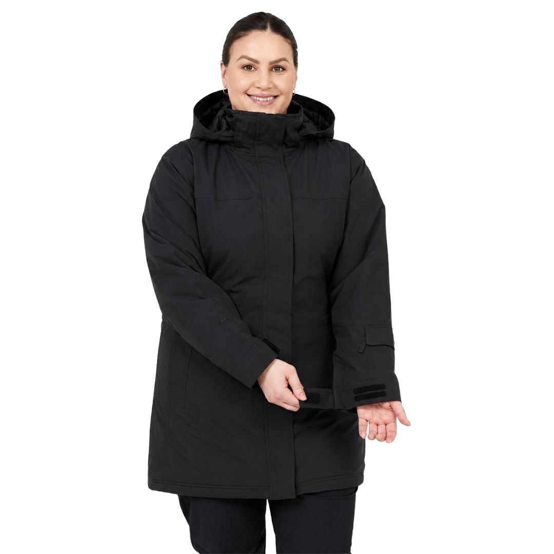 Front view of a smiling woman adjusting the adjustable wrist cuffs on her black Brooky Long Stretch Jacket.