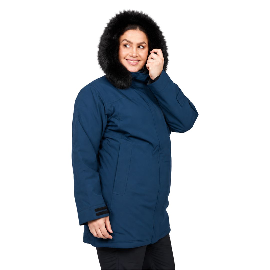 Three-quarter view of a woman smiling while wearing the hood of her tidal blue Brooky Long Stretch Jacket.