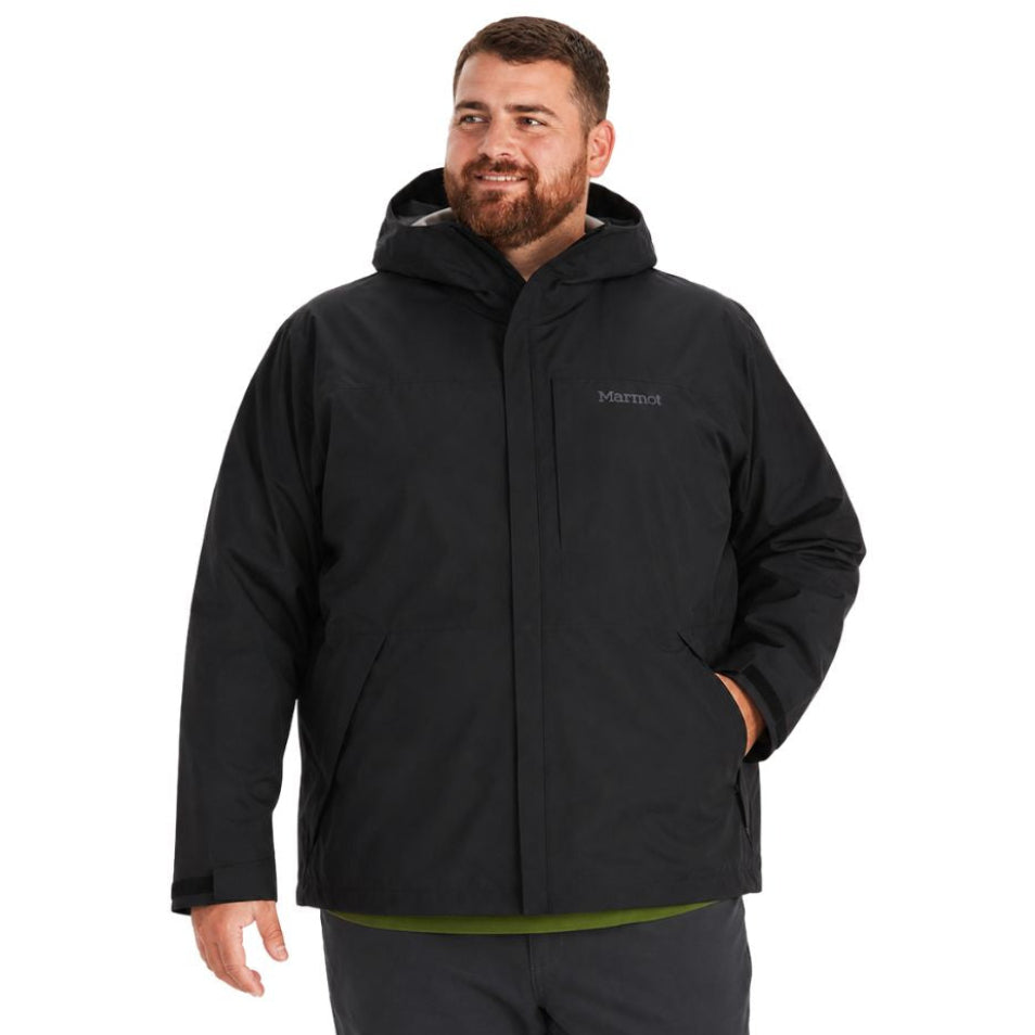 Man looking to the side wearing the Marmot Minimalist Gore-Tex Shell Men's Plus Size Rain Jacket in black with one hand in his pocket.