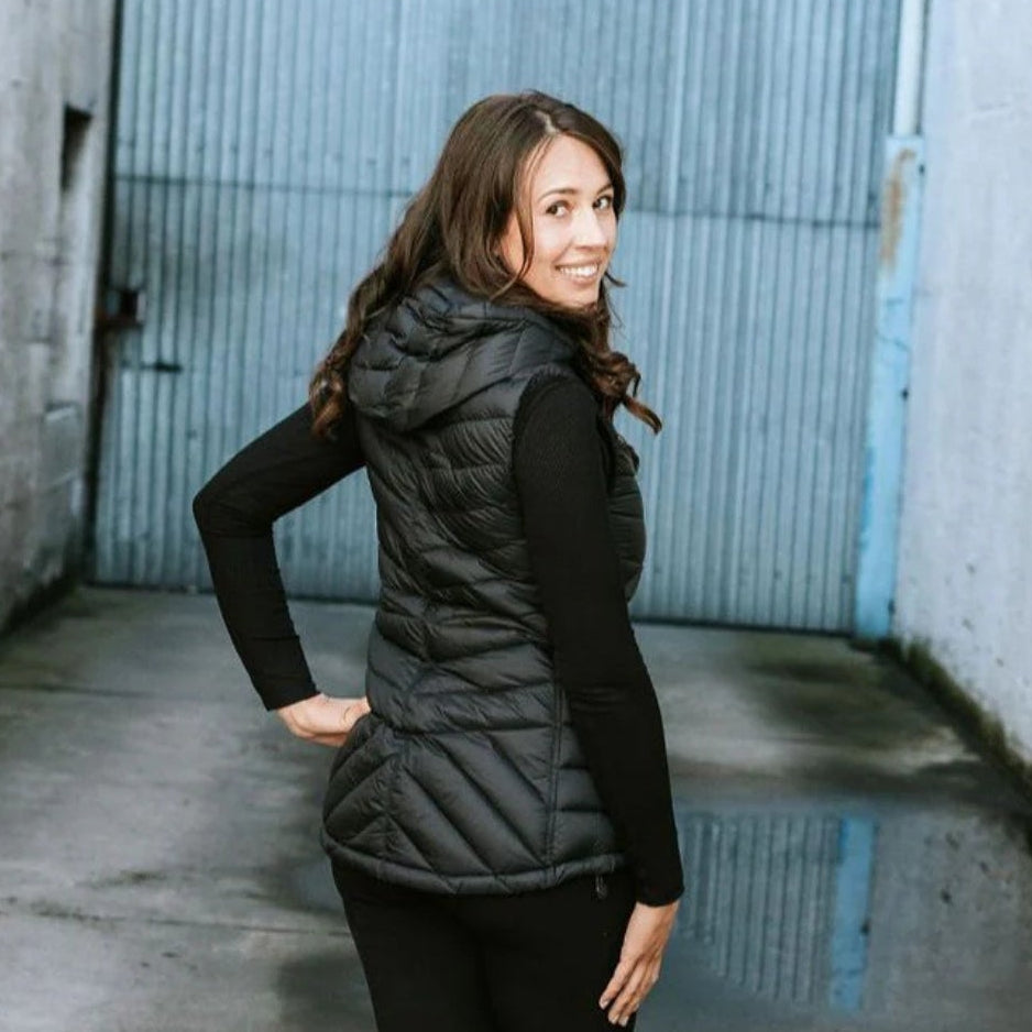 woman wearing a Moke black down puffer vest standing and doing the three-quarter Turn. Showing the plus size clothing as sold on Plus Outdoor