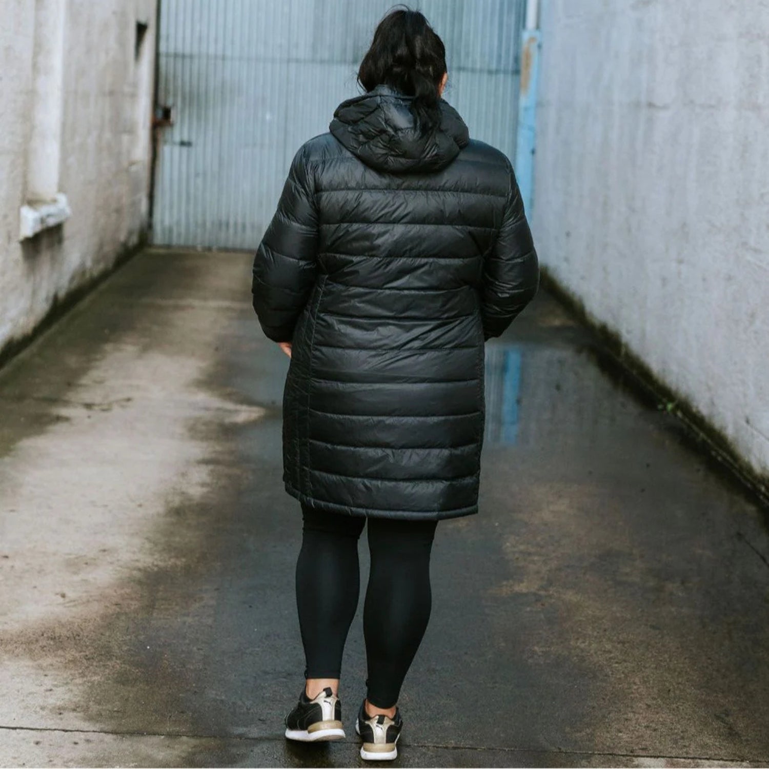 Back view of a plus-size woman wearing a long Sydney down jacket.