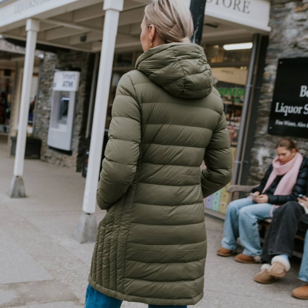 Woman walking in the alley showing the back of sydney plus size coat olive green