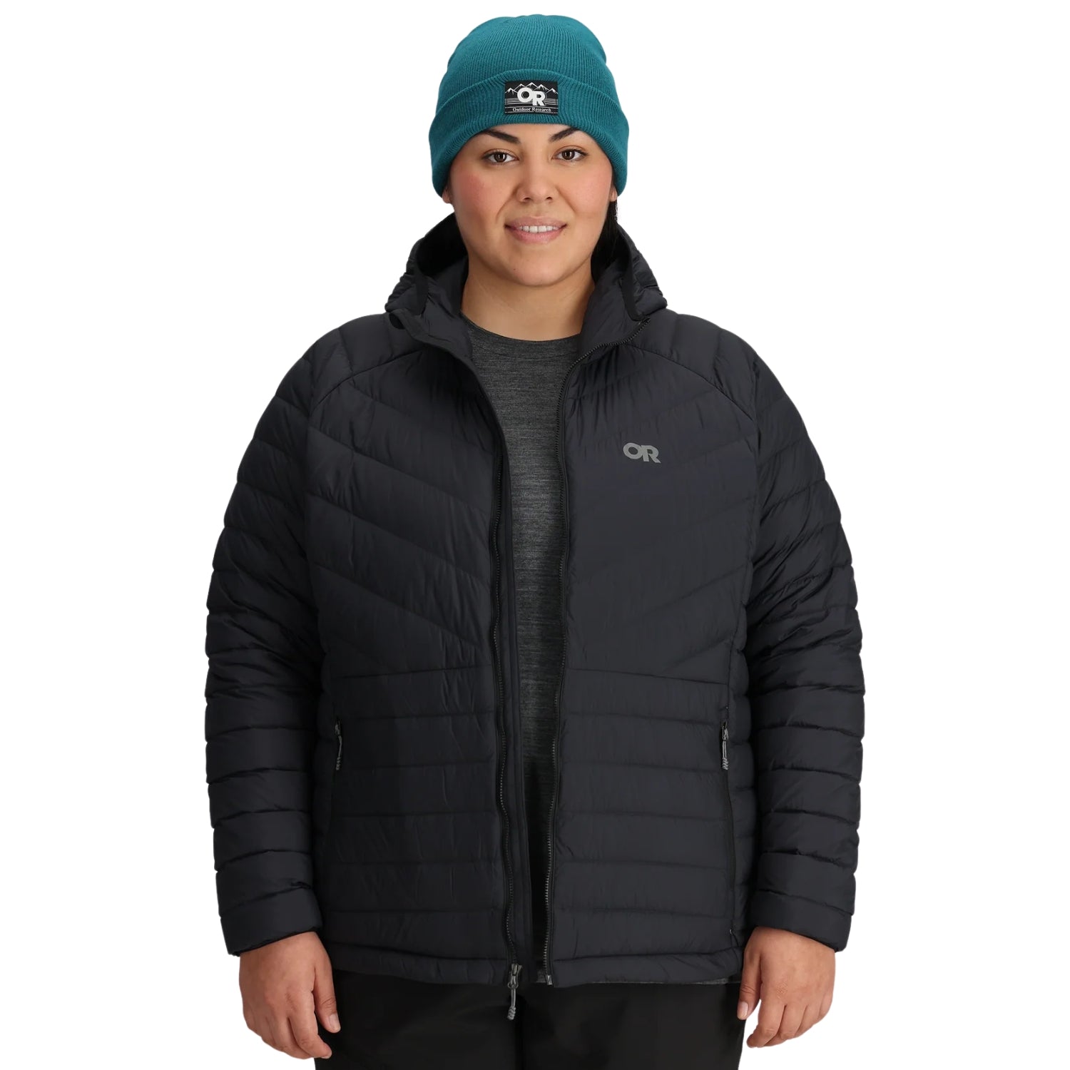 Person wearing a black puffer jacket and teal beanie with a brand logo on a white background