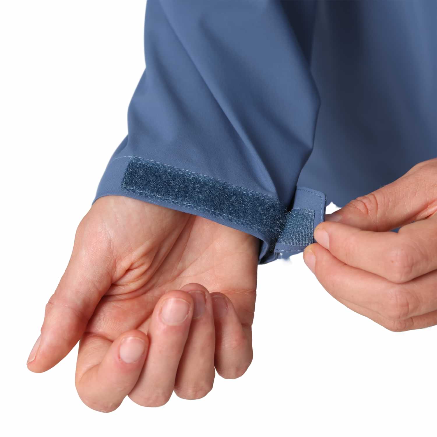 Close-up of hands adjusting the hook-and-loop wrist cuff tab on the Outdoor Research Women's Plus Size Stratoburst Rain Jacket.