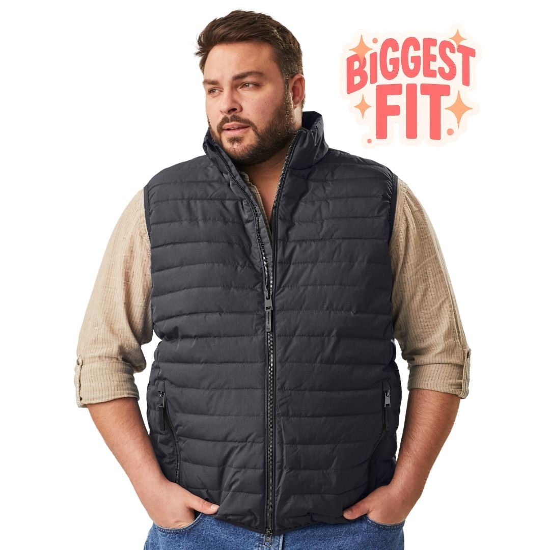 Front view of a bearded man looking to the side with hands in his pockets, wearing the STOY Men's Plus Size Quilted Puffer Vest in dark navy.