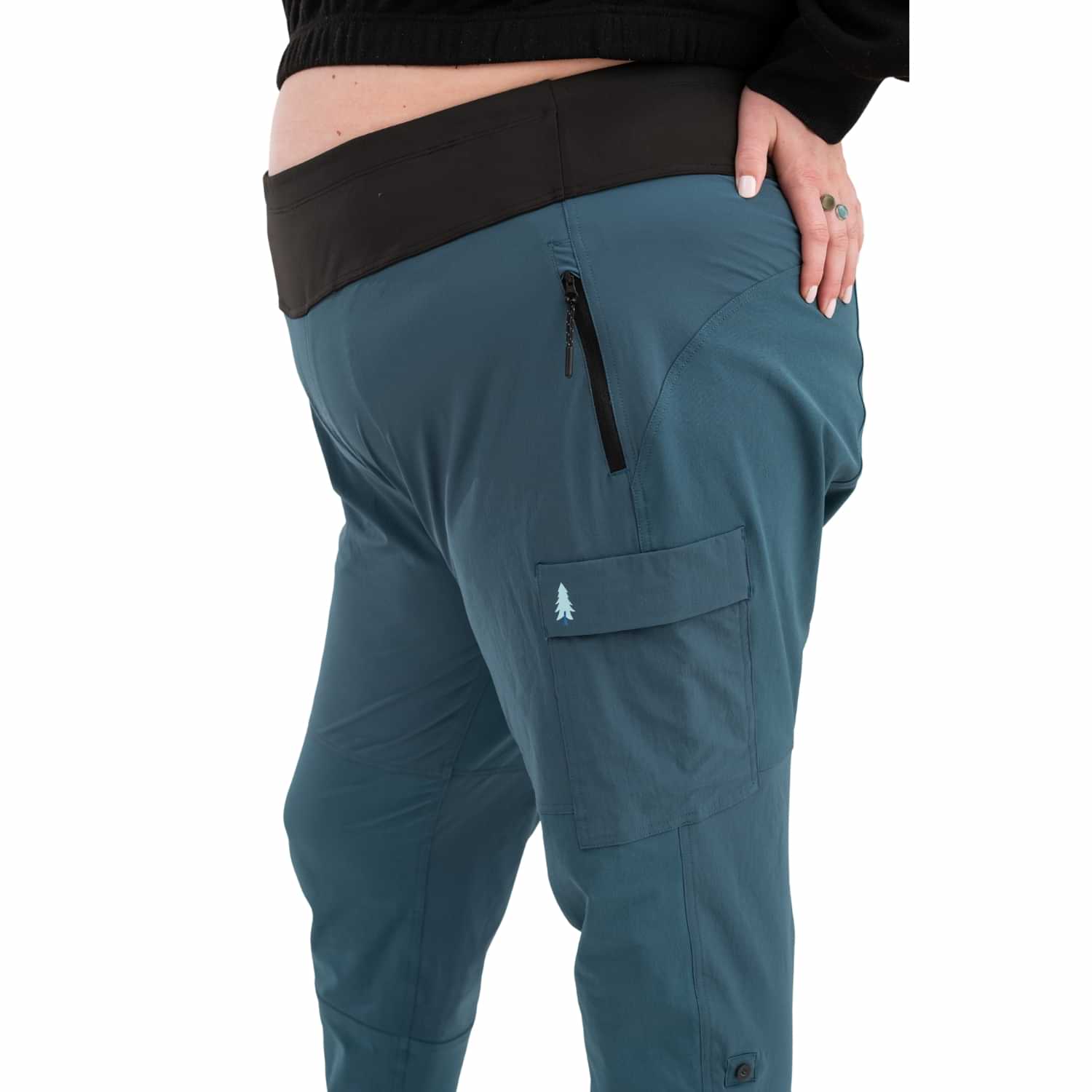 Side view of Thicket Adventure Brecken Hiking Pants BOOTY FIT in blue, featuring zip pocket, cargo pocket, and flexible stretch fit for plus sizes 18-34.