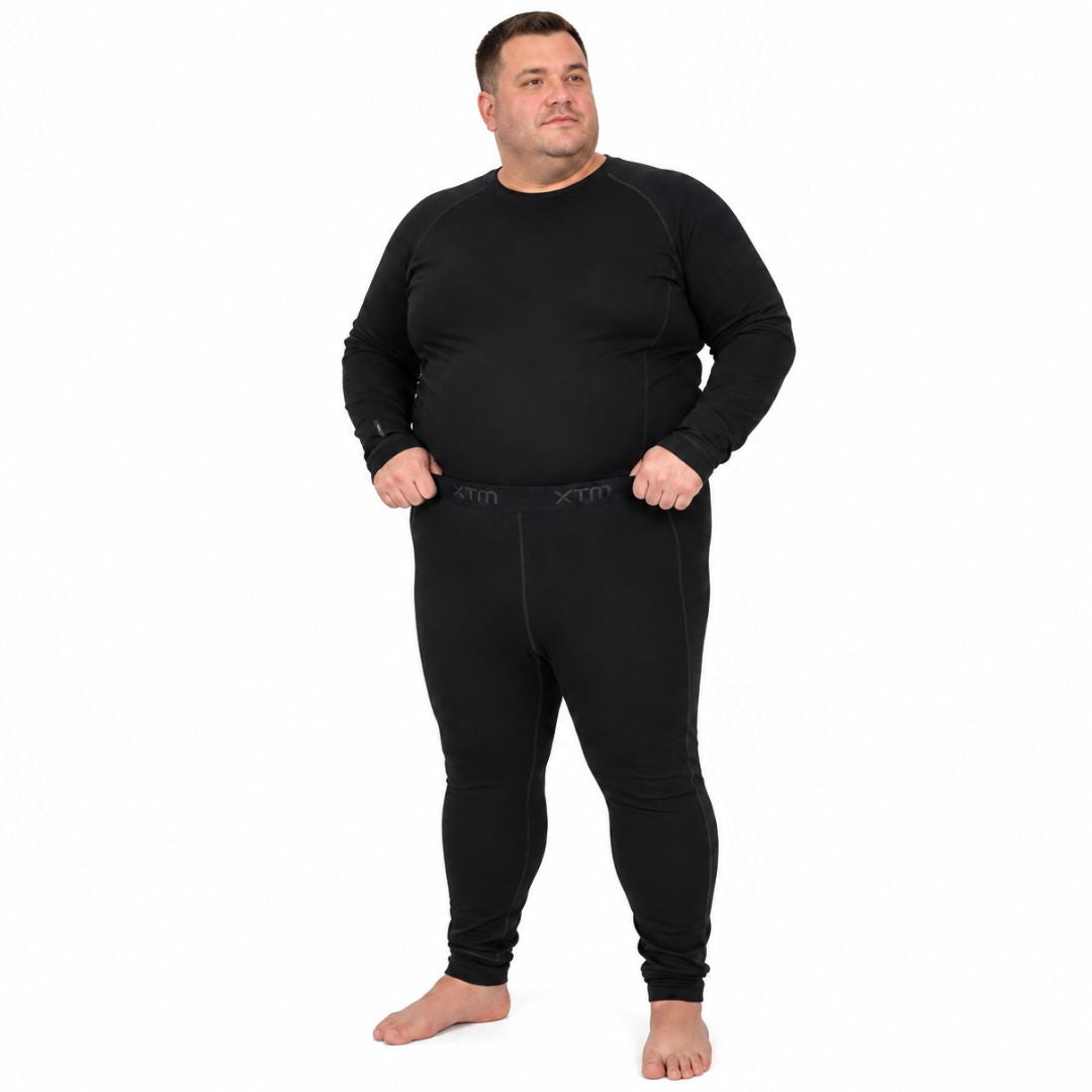 Full body front view of a man standing barefoot wearing the XTM Siberia Merino Wool Unisex Plus Size Thermal Pants in black.