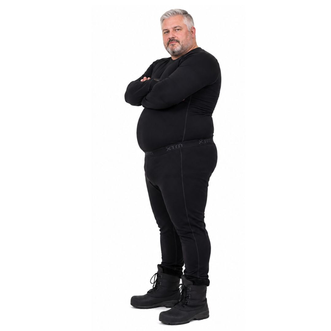 Full body profile view of a man with gray hair wearing black winter boots and XTM Siberia Merino Wool Unisex Plus Size Thermal Pants.