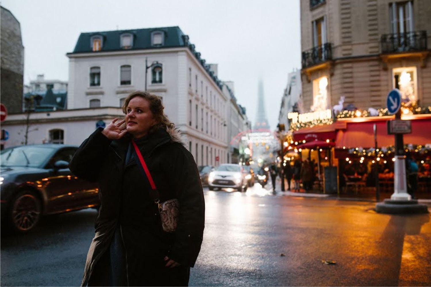 Plus size woman wearing a warm winter jacket and crossing the road on a wet Parisian street