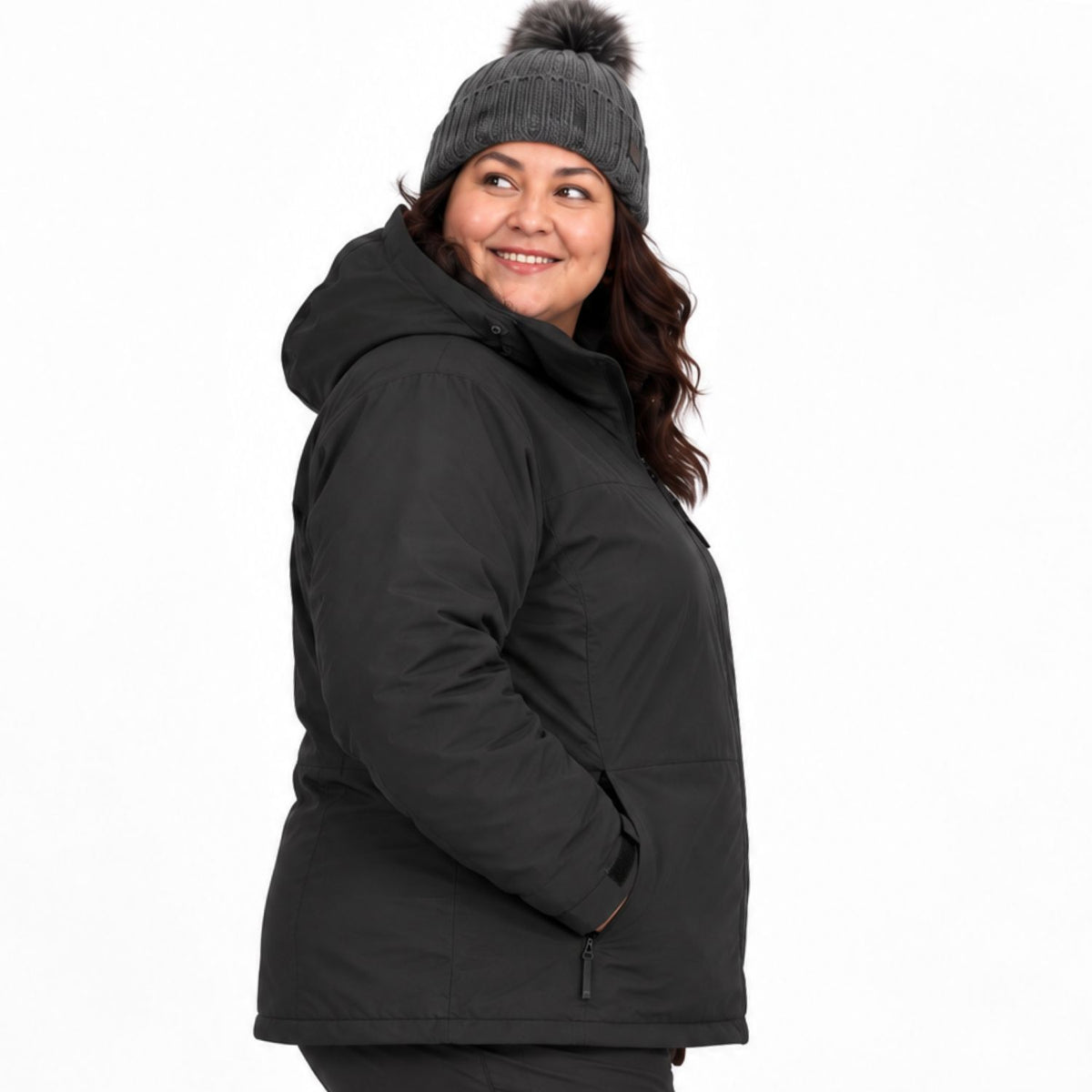 A curvy woman wearing a black hooded winter jacket and a dark gray knit beanie with a pom-pom, shown from the side against a plain white background.