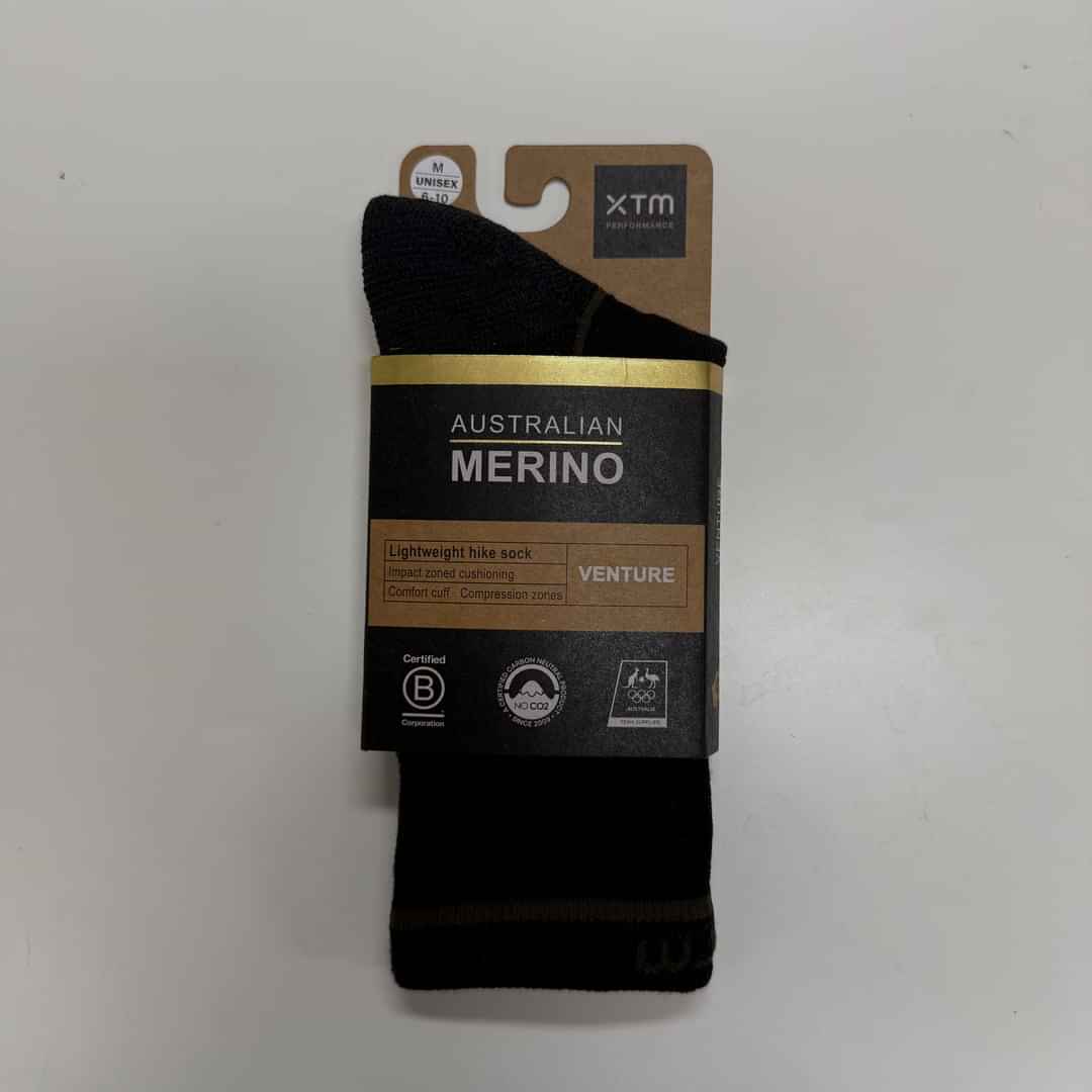 Packaged pair of black XTM Venture Lightweight Unisex Australian Merino Wool-Blend hiking socks with a cardboard wrap.
