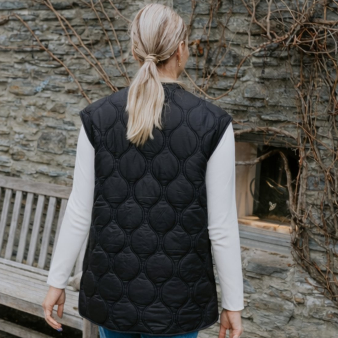 Woman facing back while wearing the moke neve vest black