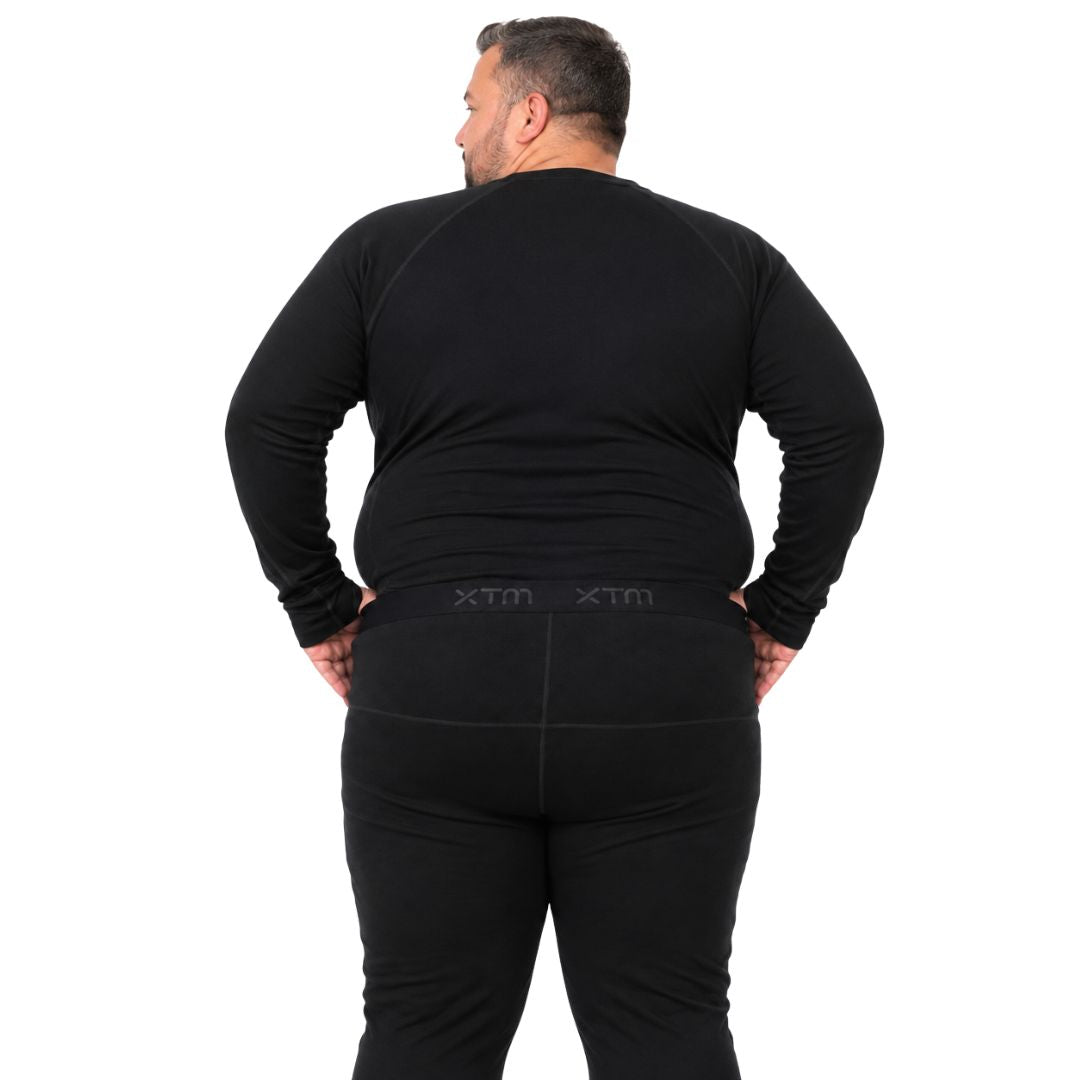 Back view of a man modeling the fit of the XTM Siberia Merino Wool Unisex Plus Size Thermal Pants in black.