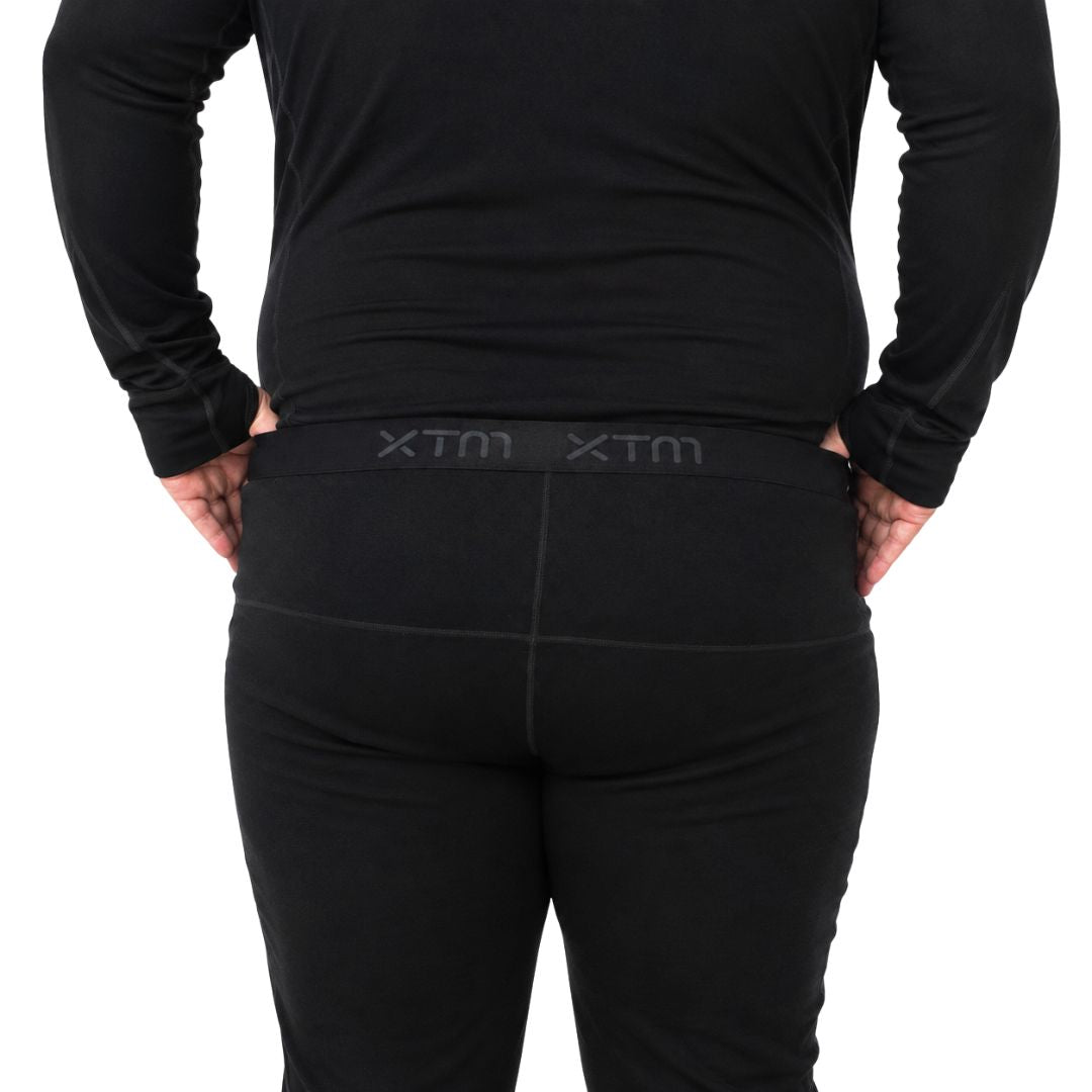 Close up rear view highlighting the flatlock seams and branded waistband of the black XTM Siberia Merino Wool Unisex Plus Size Thermal Pants.